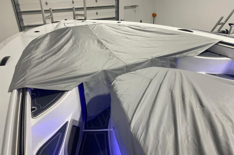 Slide: The Image of 2024 MTI V50 boat with protective cover in a garage setting. - 34