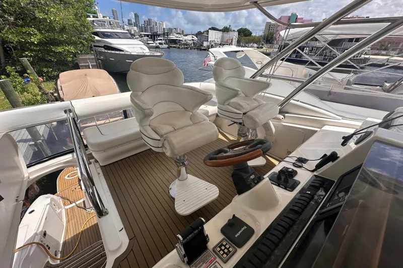 Slide: The Image of 2006 Sea Ray 58 Sedan Bridge yacht helm with luxurious seating and controls. - 12