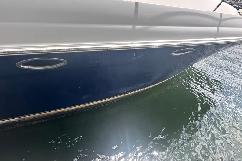 Slide: The Image of 2006 Sea Ray 58 Sedan Bridge yacht hull on water, showcasing sleek design. - 2