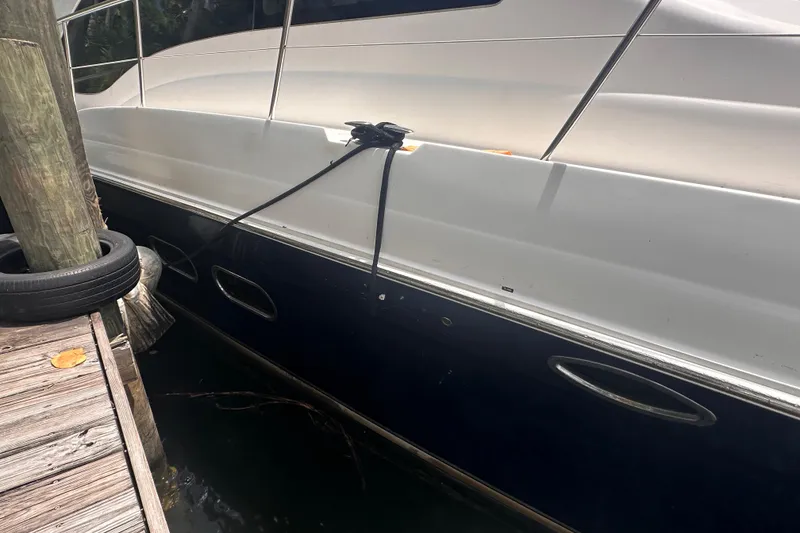 Slide: The Image of 2006 Sea Ray 58 Sedan Bridge yacht docked, side view with mooring lines. - 3