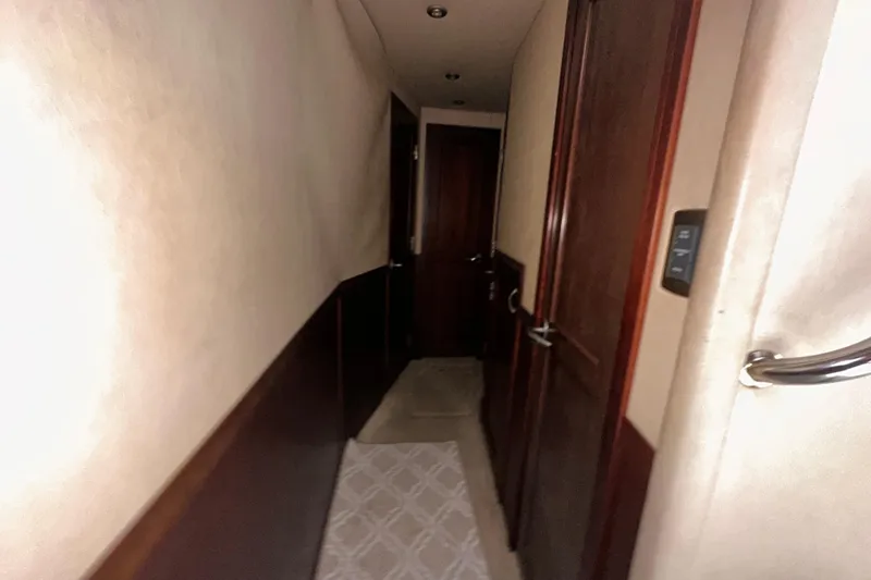Slide: The Image of Narrow hallway inside 2006 Sea Ray 58 Sedan Bridge yacht with wooden doors. - 33