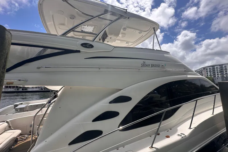 Slide: The Image of 2006 Sea Ray 58 Sedan Bridge yacht docked under a partly cloudy sky. - 5