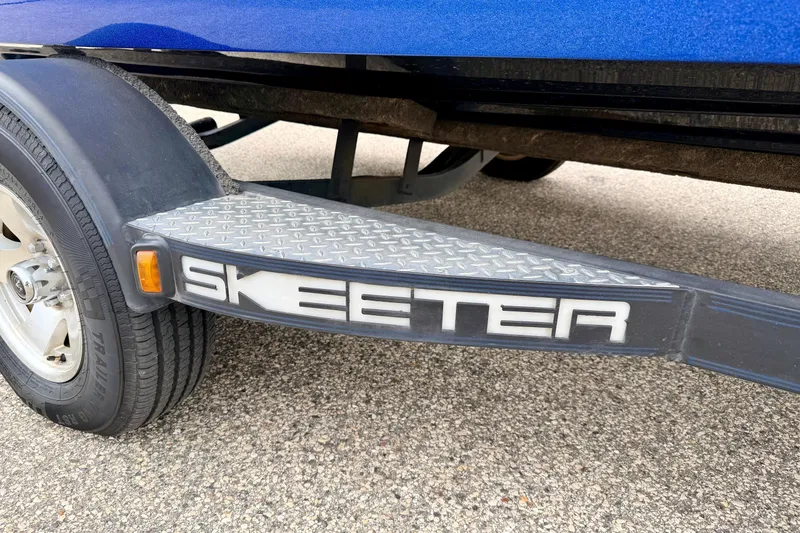 Slide: The Image of 2012 Skeeter SL 185 trailer detail with logo and tire on pavement. - 10