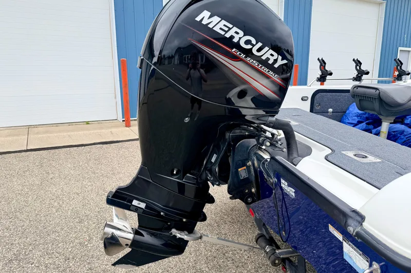 Slide: The Image of 2012 Skeeter SL 185 boat with Mercury FourStroke outboard motor, parked near a blue building. - 14