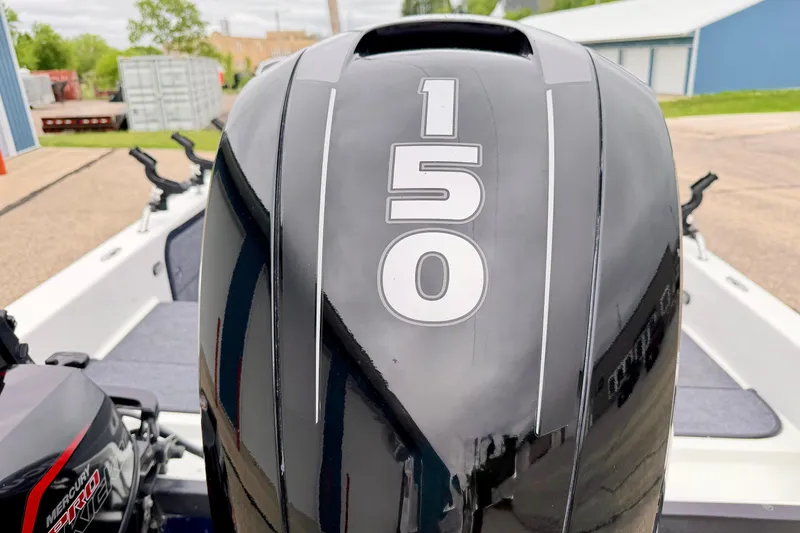 Slide: The Image of 2012 Skeeter SL 185 boat with a 150 horsepower outboard motor, parked outdoors. - 16