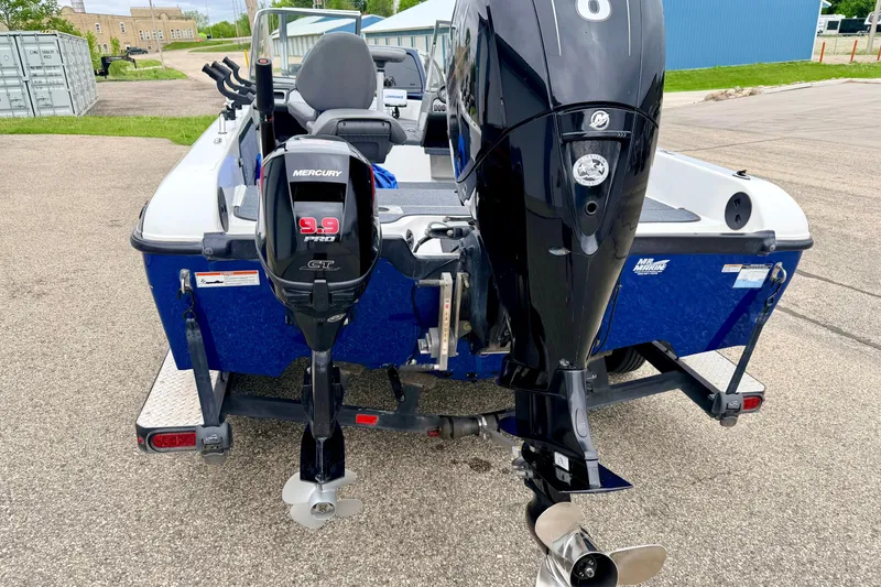 Slide: The Image of 2012 Skeeter SL 185 boat with dual Mercury outboard motors, parked on a trailer. - 19