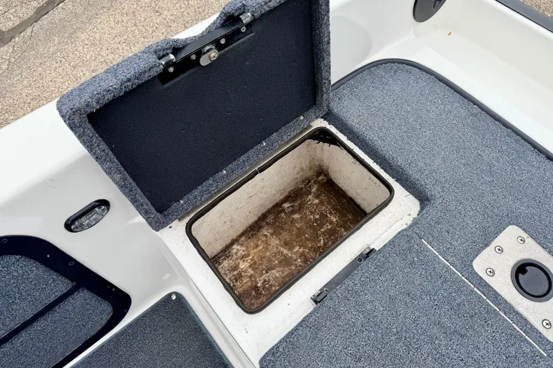 Slide: The Image of Open storage compartment on a 2012 Skeeter SL 185 boat with carpeted interior. - 22