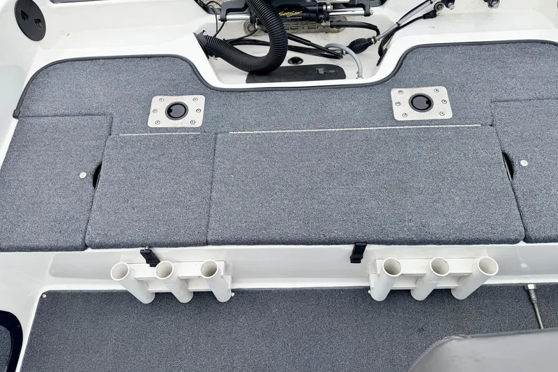 Slide: The Image of 2012 Skeeter SL 185 boat interior with carpeted deck and rod holders. - 23
