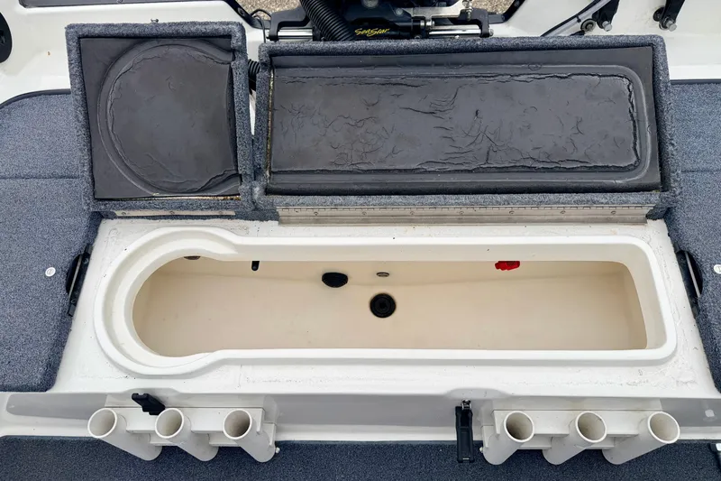 Slide: The Image of 2012 Skeeter SL 185 boat storage compartment with open lids and rod holders. - 24