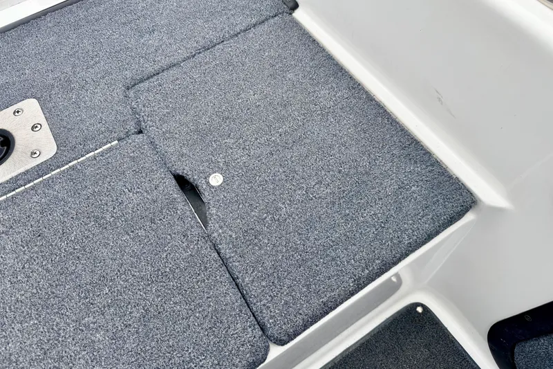 Slide: The Image of 2012 Skeeter SL 185 boat deck with gray carpet and storage compartment. - 27