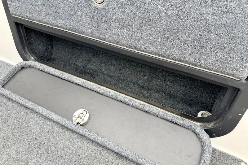 Slide: The Image of Open storage compartment on a 2012 Skeeter SL 185 boat, featuring carpeted interior. - 31