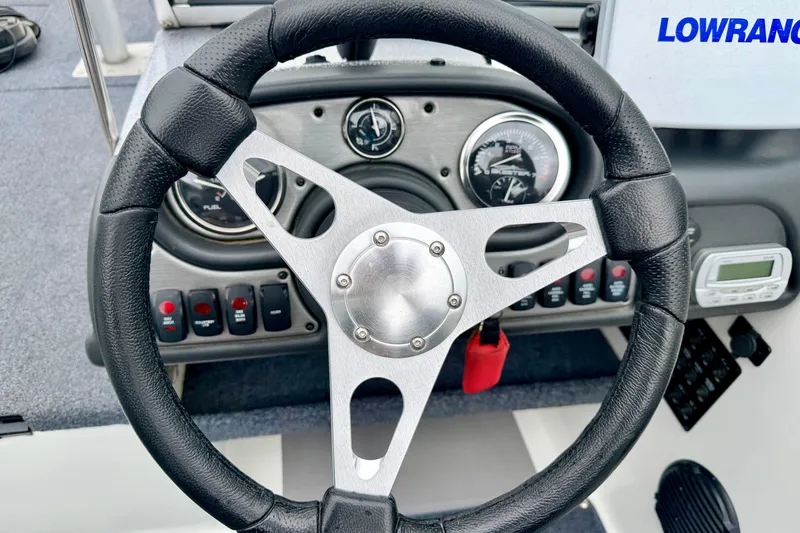 Slide: The Image of Steering wheel and dashboard of a 2012 Skeeter SL 185 boat with gauges and controls. - 38
