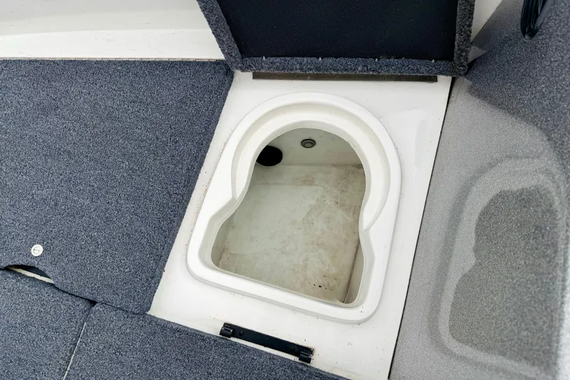 Slide: The Image of Open storage compartment in 2012 Skeeter SL 185 boat with carpeted flooring. - 52