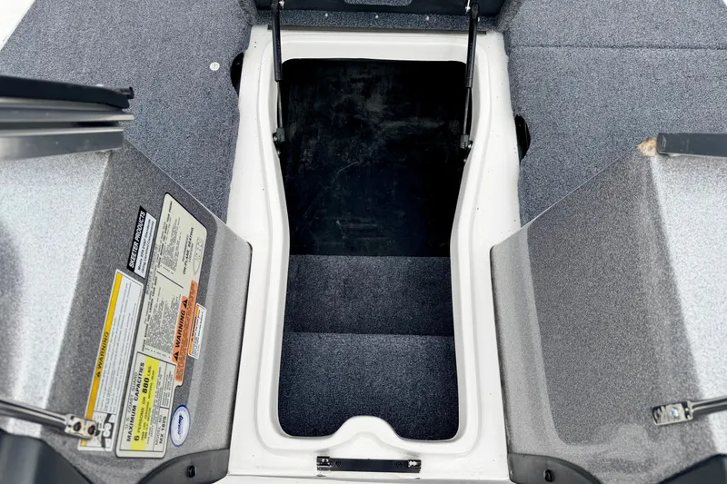 Slide: The Image of Open storage compartment in a 2012 Skeeter SL 185 boat, featuring carpeted interior. - 55