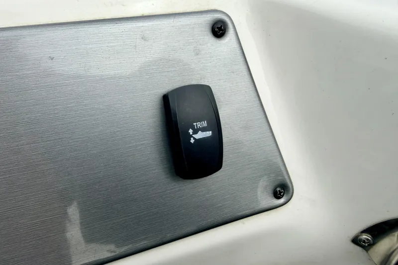 Slide: The Image of Trim switch on 2012 Skeeter SL 185 boat dashboard, mounted on a metallic panel. - 58