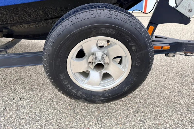 Slide: The Image of Trailer wheel of a 2012 Skeeter SL 185 boat on pavement. - 68