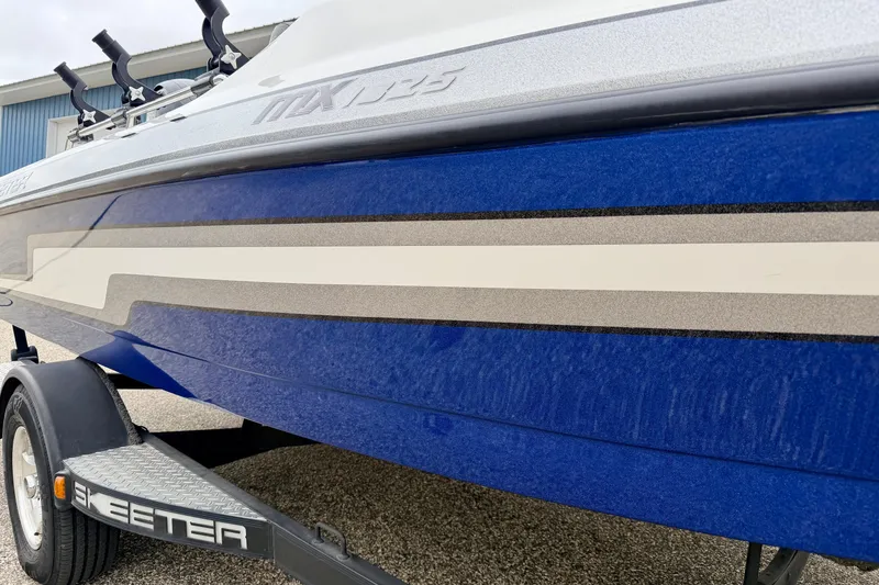 Slide: The Image of 2012 Skeeter SL 185 boat with blue and white detailing on a trailer. - 8