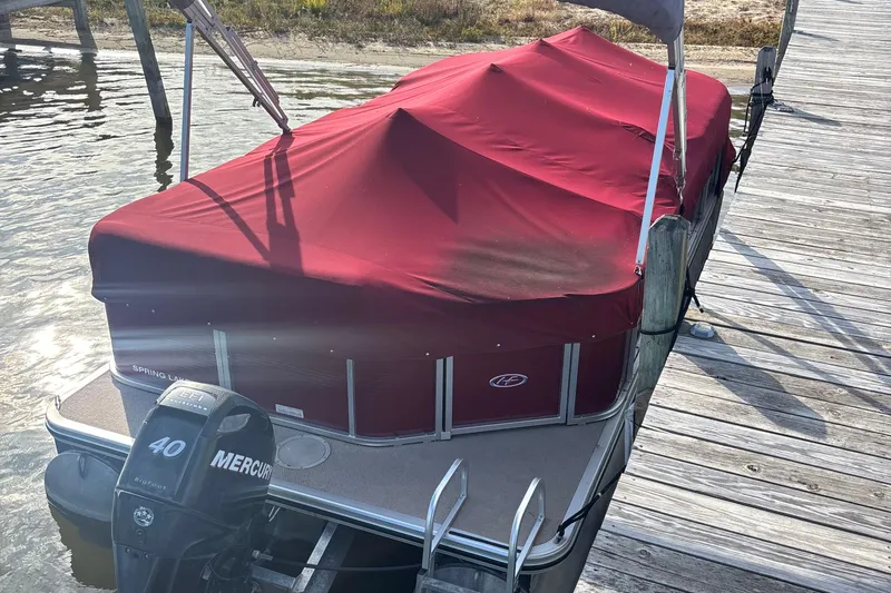 The Image of 2011 Harris Cruiser 200 pontoon boat with red cover docked by wooden pier. - 1