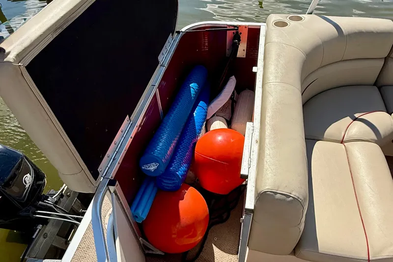 Slide: The Image of Open storage compartment on 2011 Harris Cruiser 200 boat with pool noodles and buoys. - 10