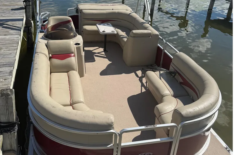 Slide: The Image of 2011 Harris Cruiser 200 pontoon boat with beige seating, docked by wooden pier. - 4