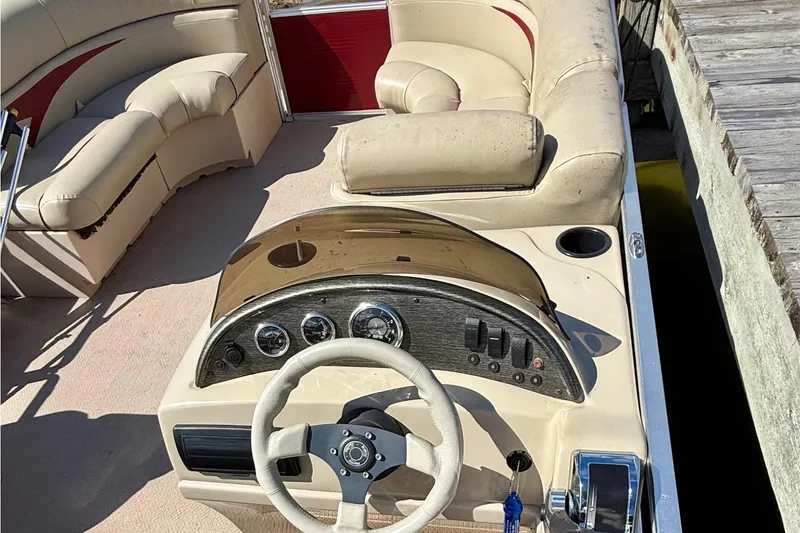 Slide: The Image of 2011 Harris Cruiser 200 boat interior with beige seating and steering console. - 7