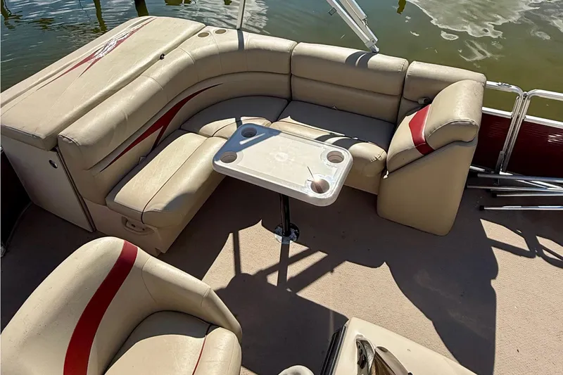 Slide: The Image of 2011 Harris Cruiser 200 pontoon boat interior with beige seating and table on water. - 8
