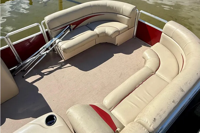 Slide: The Image of 2011 Harris Cruiser 200 pontoon boat interior with beige seating and red accents. - 9