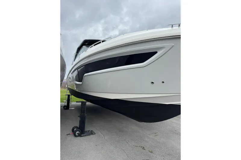 Slide: The Image of 2024 Cruisers Yachts 38 GLS OB, sleek design, displayed on a stand, overcast sky. - 10