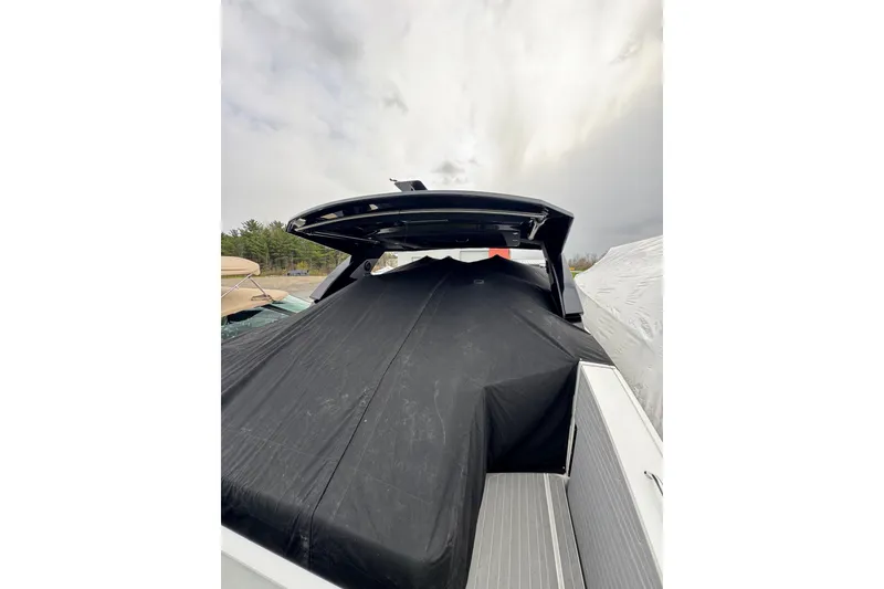 Slide: The Image of 2024 Cruisers Yachts 38 GLS OB covered, docked under cloudy sky. - 15