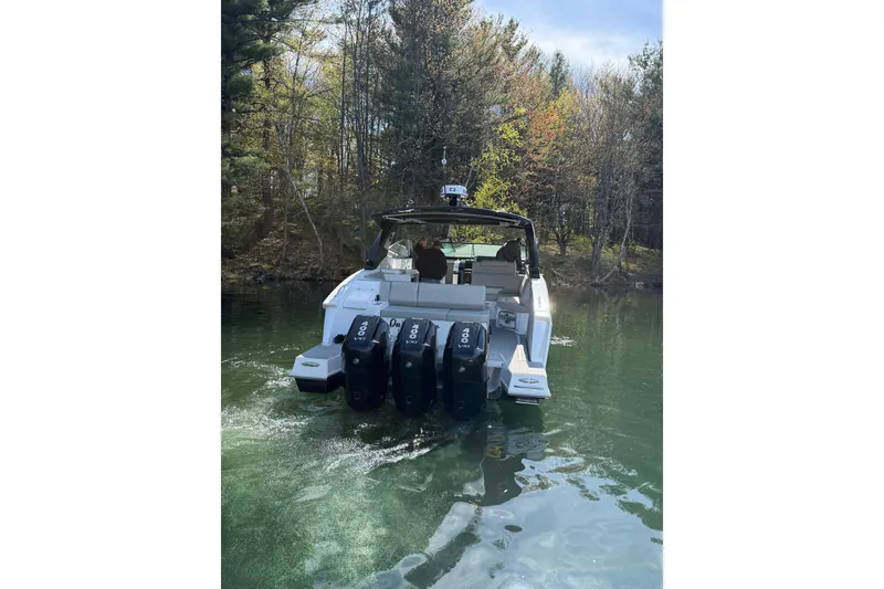 Slide: The Image of 2024 Cruisers Yachts 38 GLS OB on serene lake, surrounded by trees. - 3