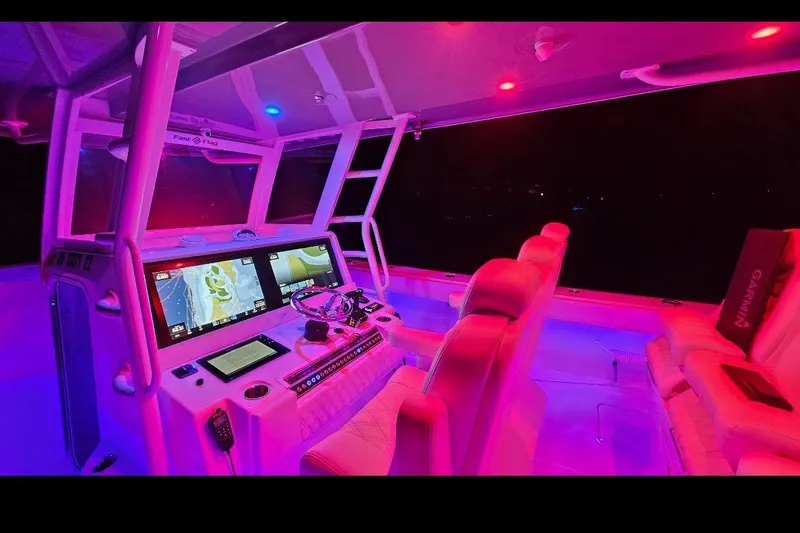 Slide: The Image of 2023 Invincible 46 Catamaran cockpit with illuminated controls and seating at night. - 5