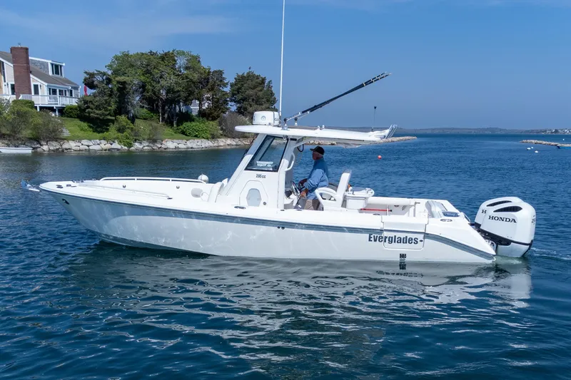 Slide: The Image of 2011 Everglades 295 Center Console boat on calm water near a coastal home. - 11