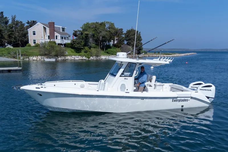 Slide: The Image of 2011 Everglades 295 Center Console boat on water near a coastal house. - 13
