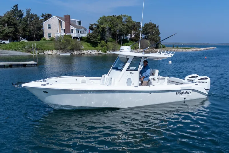 Slide: The Image of 2011 Everglades 295 Center Console boat on calm water near a coastal home. - 14