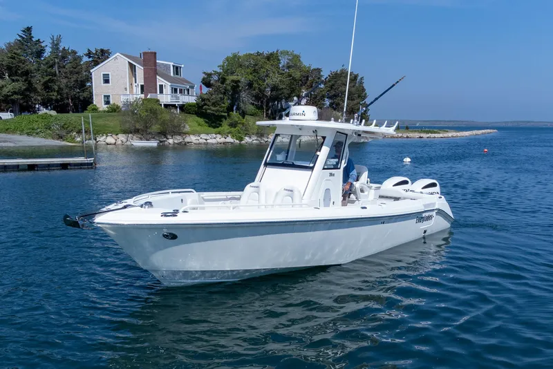 Slide: The Image of 2011 Everglades 295 Center Console boat on calm water near a coastal house. - 15