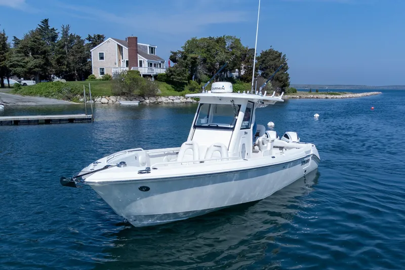 Slide: The Image of 2011 Everglades 295 Center Console boat on calm water near a coastal house. - 16