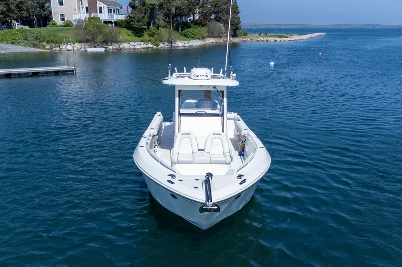Slide: The Image of 2011 Everglades 295 Center Console boat on calm water near a coastal home. - 18