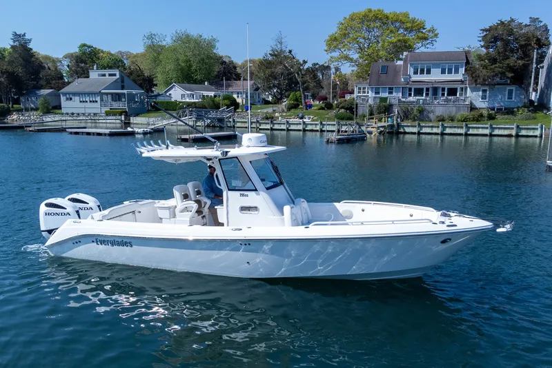 Slide: The Image of 2011 Everglades 295 Center Console boat on calm water near waterfront homes. - 2