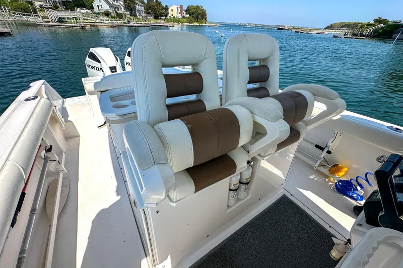 Slide: The Image of 2011 Everglades 295 Center Console boat interior with dual Honda engines, docked by the water. - 24