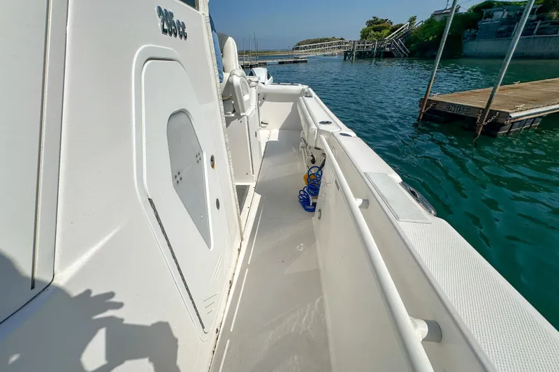 Slide: The Image of 2011 Everglades 295 Center Console boat docked by the water, showcasing sleek design. - 30