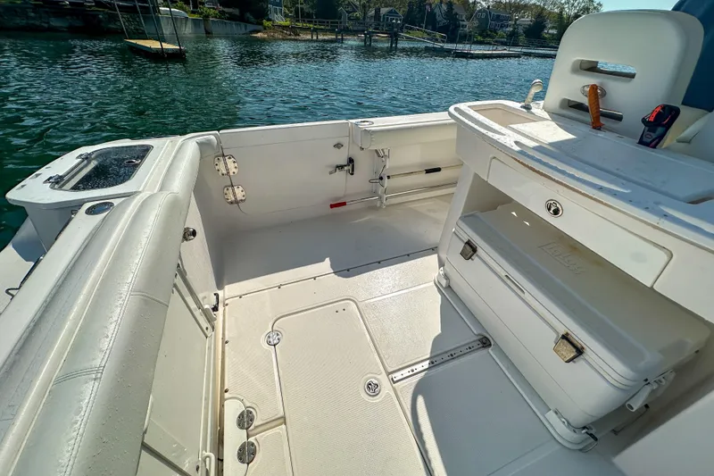 Slide: The Image of 2011 Everglades 295 Center Console boat interior with seating and storage, docked by the water. - 32
