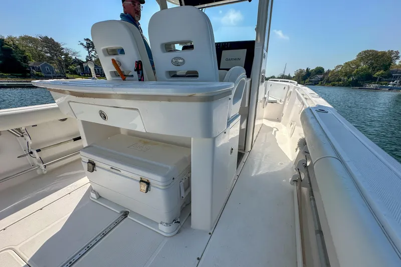 Slide: The Image of 2011 Everglades 295 Center Console boat interior with seating and storage, docked on a sunny day. - 35