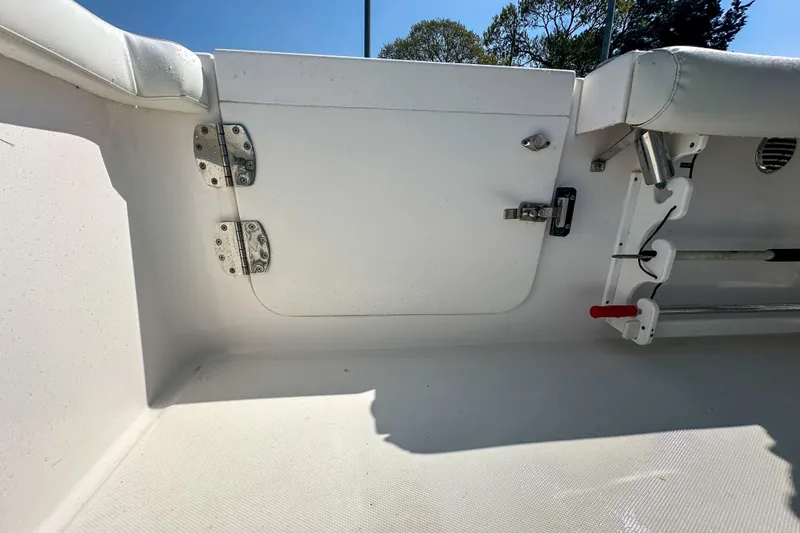 Slide: The Image of Interior view of a 2011 Everglades 295 Center Console boat, featuring white seating and storage. - 36