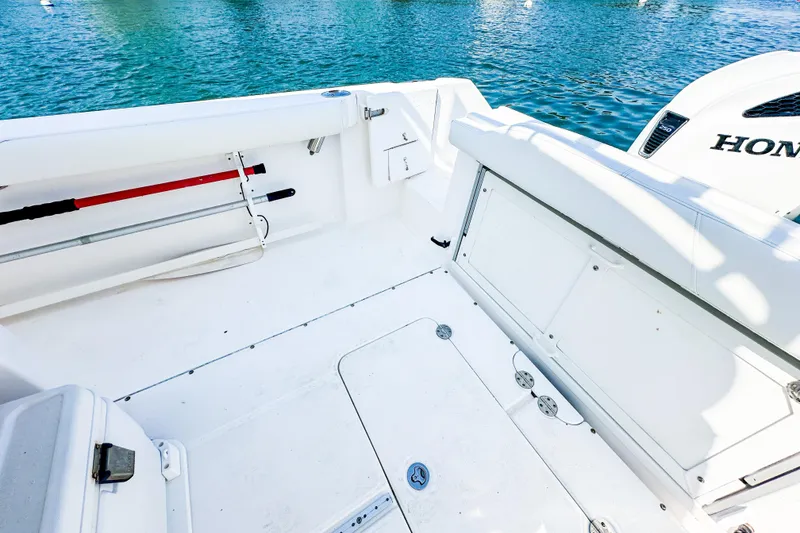 Slide: The Image of 2011 Everglades 295 Center Console boat interior with white seating and Honda engine. - 38