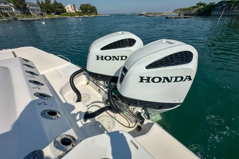 Slide: The Image of Twin Honda outboard engines on a 2011 Everglades 295 Center Console boat in a scenic harbor. - 39