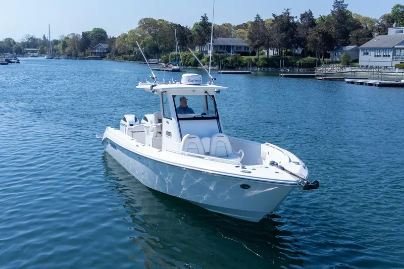 Slide: The Image of 2011 Everglades 295 Center Console boat on calm water near shoreline homes. - 4