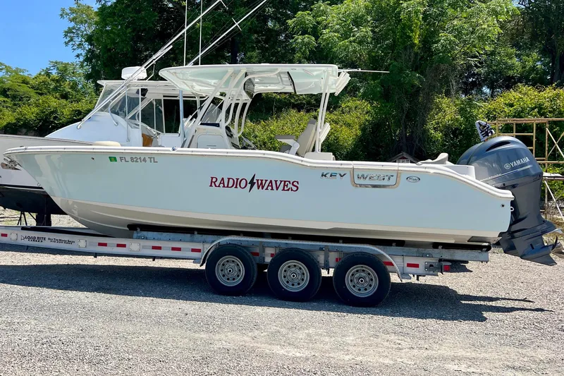 The Image of 2023 Key West 263 FS boat on trailer with Yamaha engine, labeled "Radio Waves." - 1