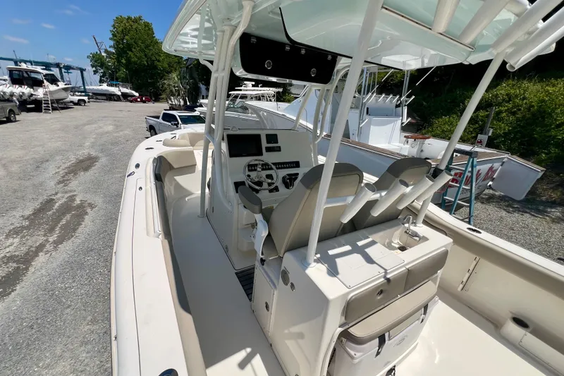 Slide: The Image of 2023 Key West 263 FS boat interior with helm, seats, and console in a marina setting. - 10