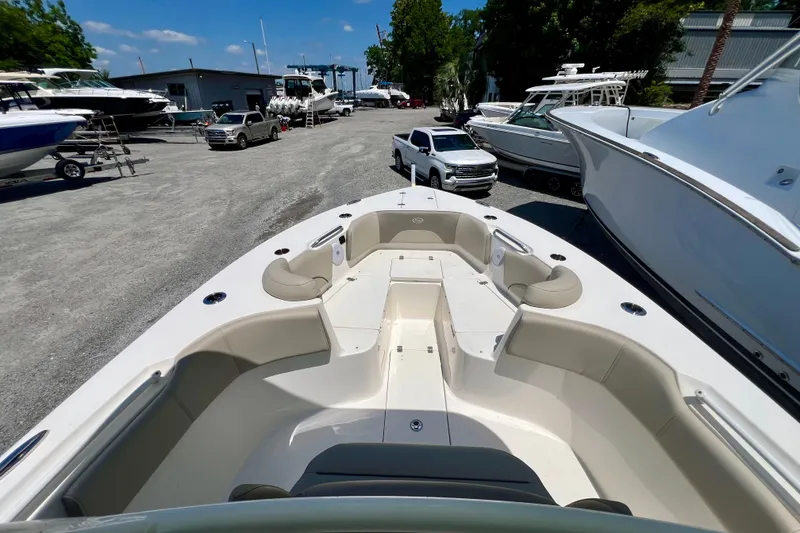 Slide: The Image of 2023 Key West 263 FS boat in a marina, surrounded by other boats and vehicles. - 14