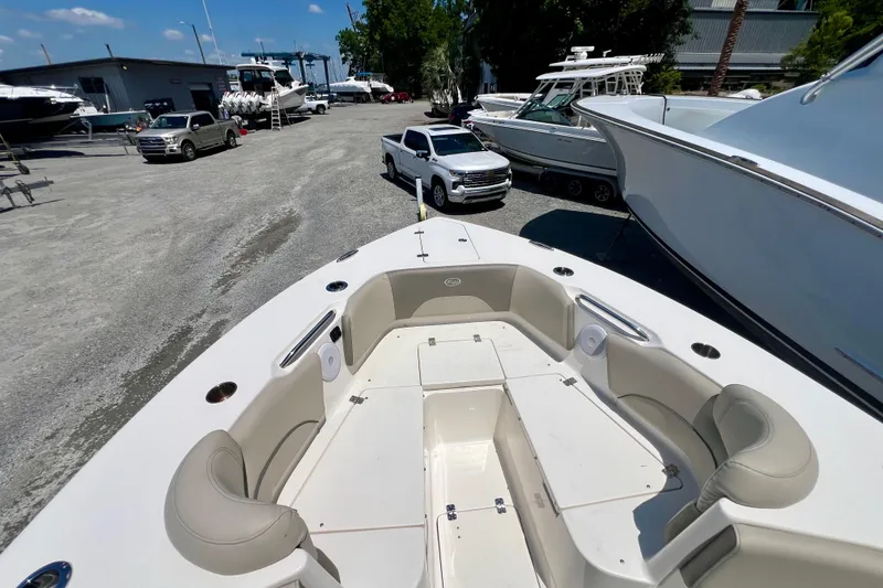Slide: The Image of 2023 Key West 263 FS boat interior with seating, parked near other boats and vehicles. - 16